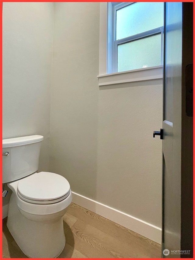 bathroom with toilet and wood-type flooring