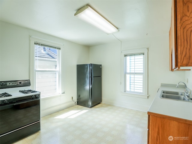 kitchen with a healthy amount of sunlight, black appliances, and sink