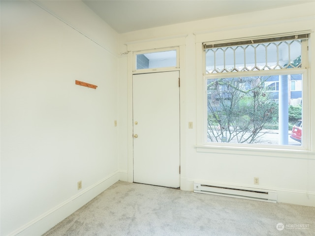 foyer entrance featuring baseboard heating and light carpet