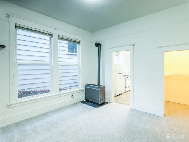 misc room with light carpet and a wood stove