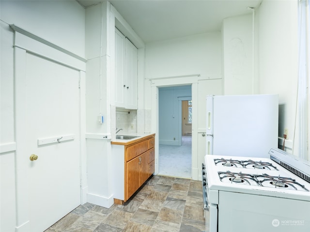 kitchen featuring white cabinets, white appliances, tasteful backsplash, and sink