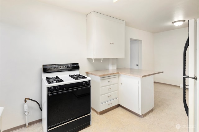 kitchen featuring white appliances, kitchen peninsula, and white cabinets