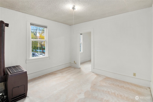 unfurnished room with a textured ceiling and light colored carpet