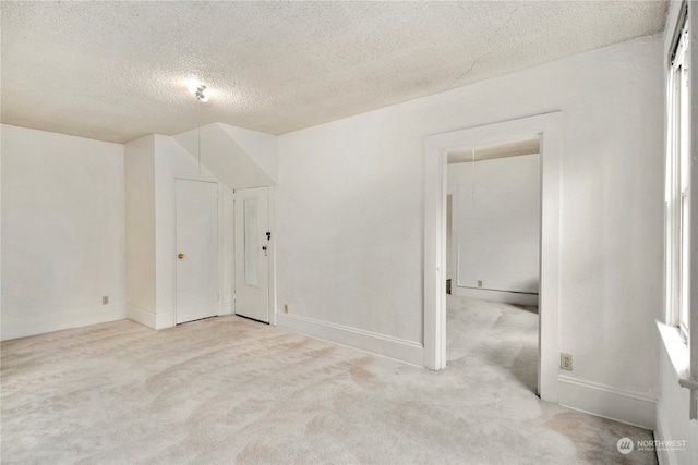 carpeted empty room featuring a textured ceiling