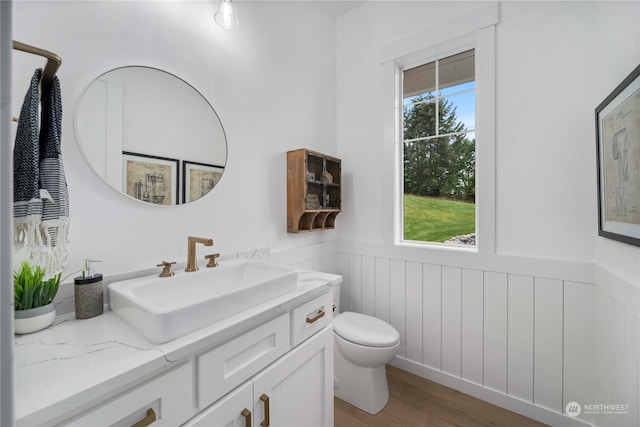 bathroom with hardwood / wood-style floors, vanity, plenty of natural light, and toilet