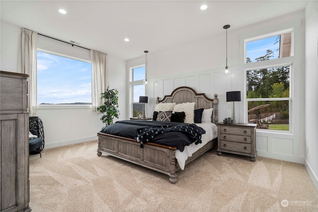 bedroom with light carpet and multiple windows