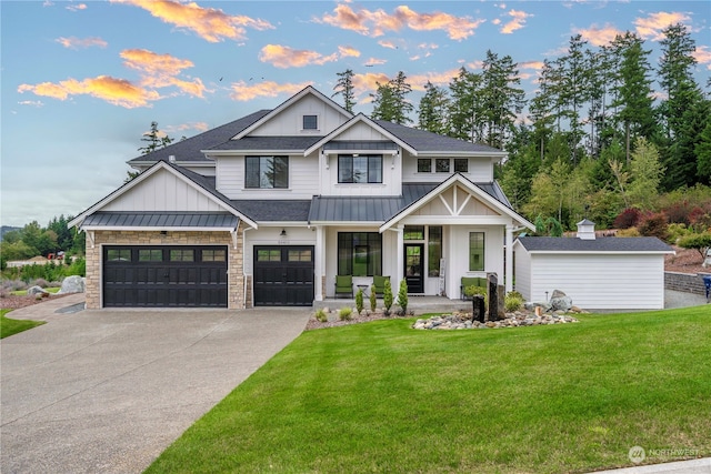 view of front of house with a garage, a porch, and a yard