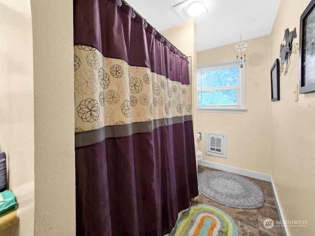 bathroom with toilet and heating unit