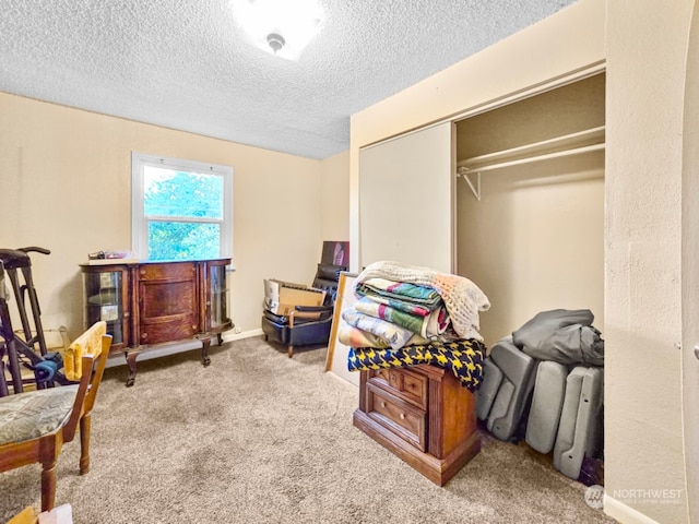 bedroom featuring a closet, light colored carpet, and a textured ceiling