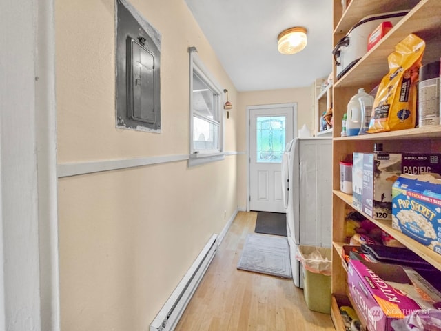 storage room featuring electric panel and a baseboard heating unit