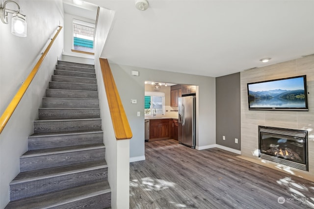 stairway with a fireplace, hardwood / wood-style floors, and sink