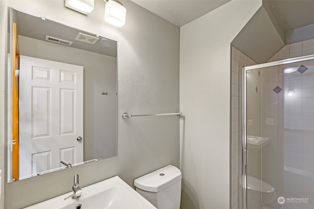 bathroom featuring sink, an enclosed shower, and toilet