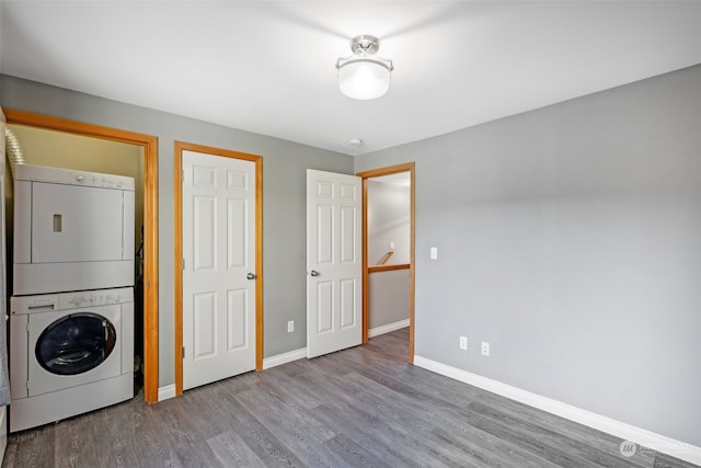 laundry room featuring light wood-type flooring and stacked washer / dryer