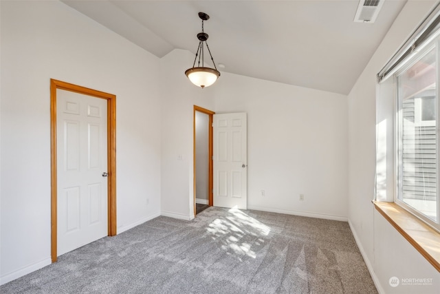 carpeted spare room with lofted ceiling