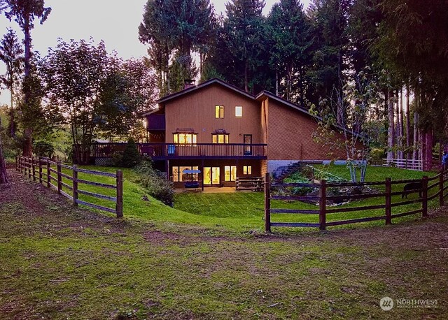 rear view of property with a patio, a yard, and a deck