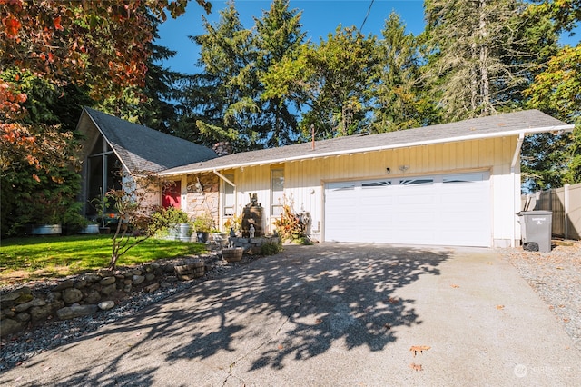 ranch-style home featuring a garage and a front lawn