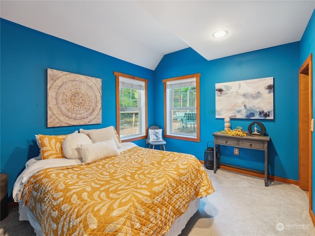 bedroom with lofted ceiling and light carpet