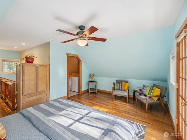 bedroom with washer and dryer, light hardwood / wood-style floors, lofted ceiling, and ceiling fan