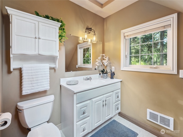 bathroom with vanity, toilet, and plenty of natural light