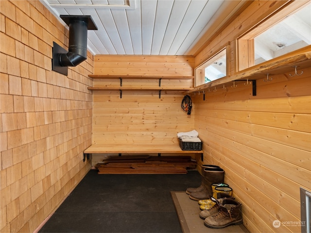 mudroom featuring a wood stove and wood walls