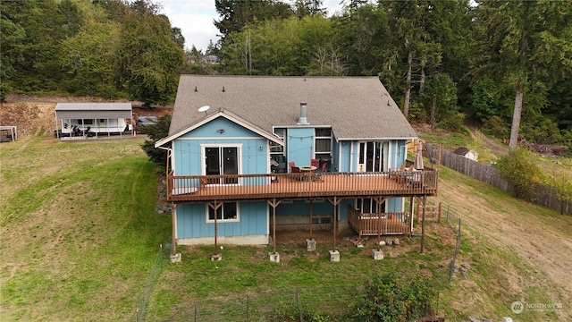 rear view of property featuring a deck and a lawn