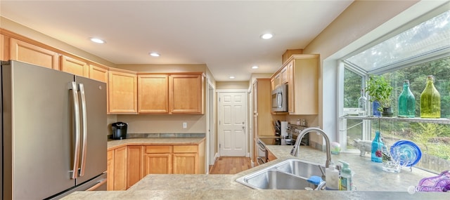 kitchen featuring stainless steel appliances, light brown cabinets, and sink