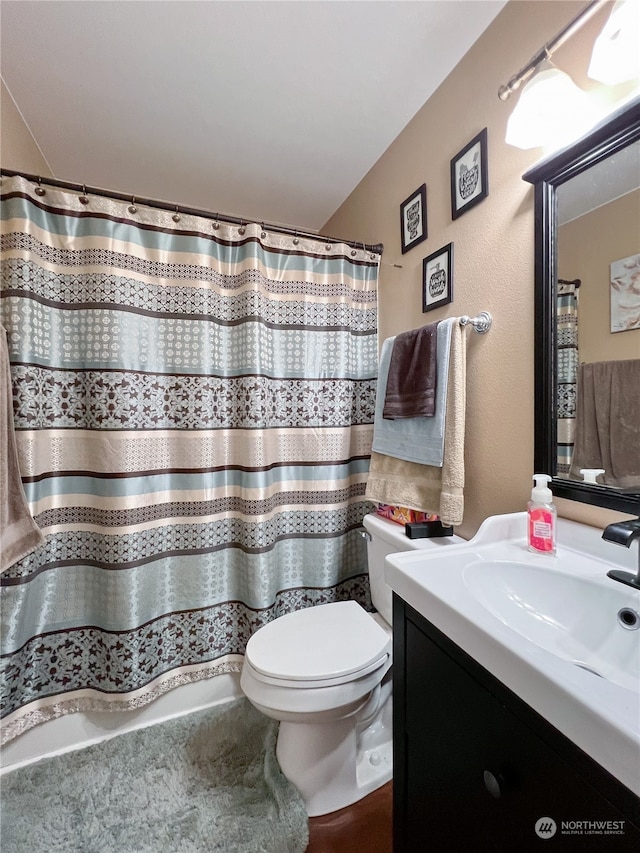 bathroom with walk in shower, vanity, and toilet