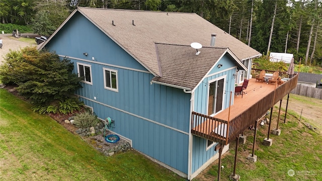 rear view of house with a deck and a yard