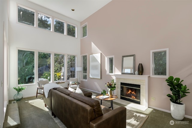 living room with carpet flooring, a fireplace, and a high ceiling