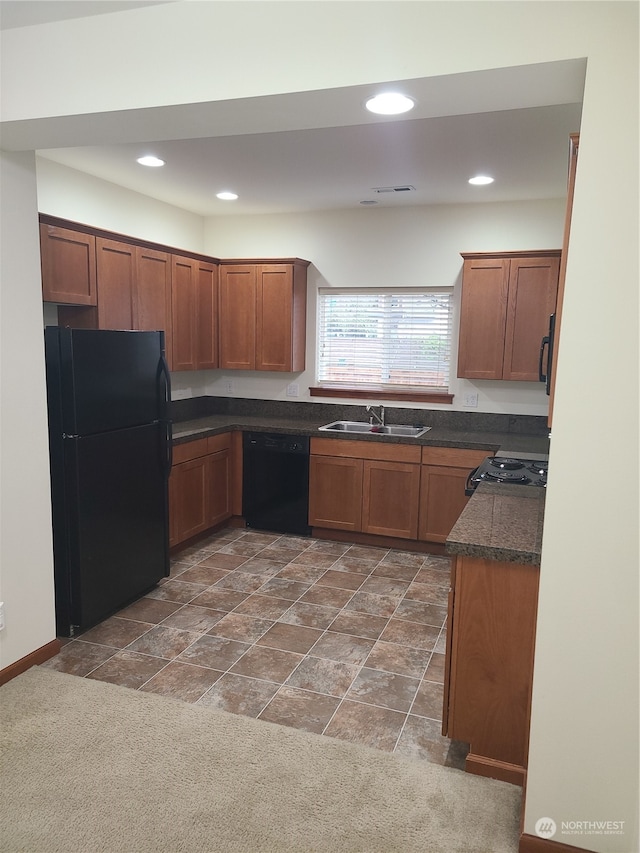 kitchen with dark carpet, black appliances, and sink