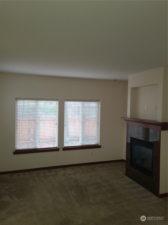 unfurnished living room with dark colored carpet