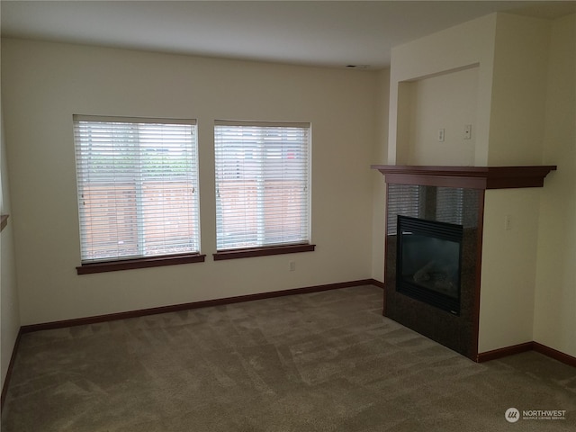 unfurnished living room featuring dark carpet and a fireplace