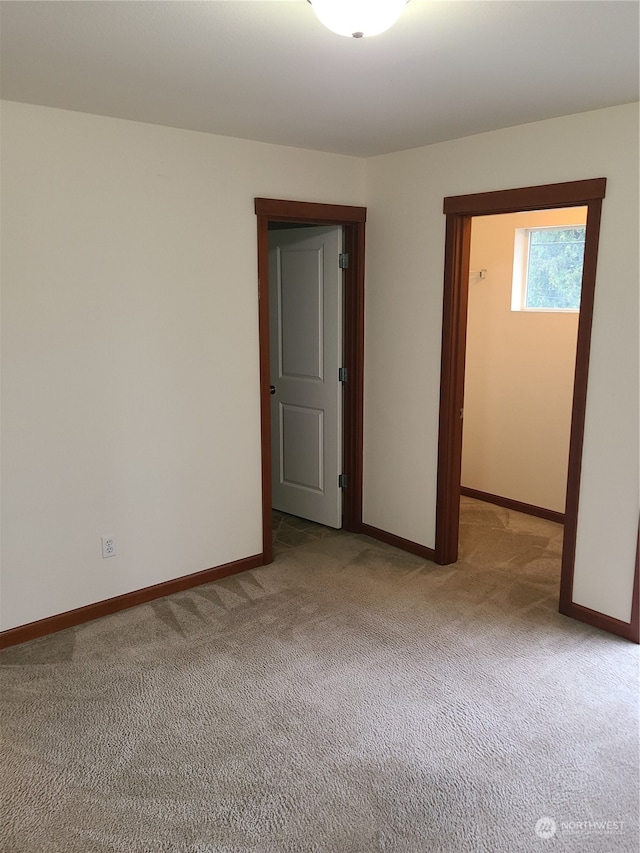 unfurnished room featuring light colored carpet