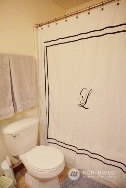 bathroom with toilet and tile patterned floors