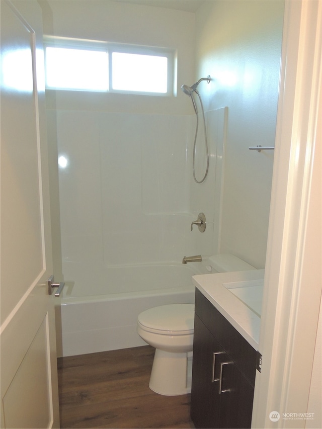 full bathroom with shower / bathing tub combination, vanity, hardwood / wood-style floors, and toilet