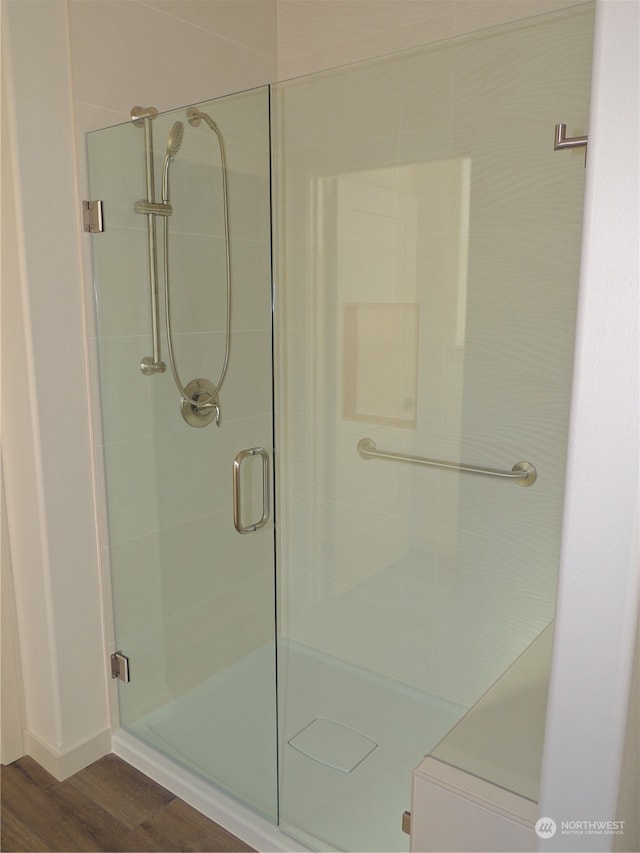 bathroom featuring a shower with door and hardwood / wood-style flooring