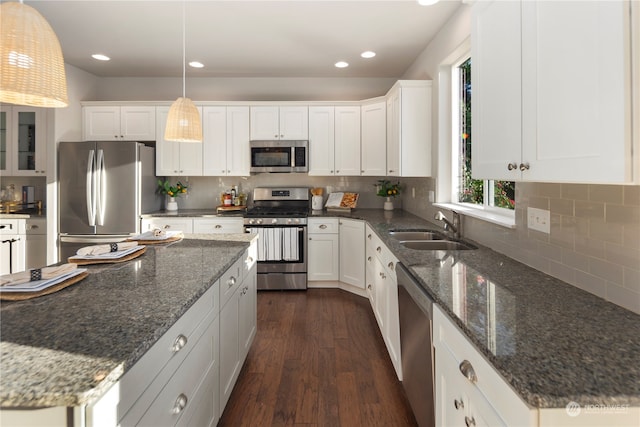 kitchen with white cabinets, stainless steel appliances, hanging light fixtures, and sink