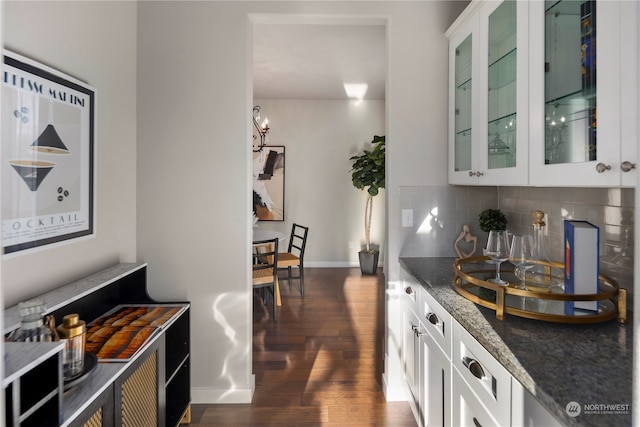 kitchen with dark stone counters, decorative backsplash, white cabinetry, and dark hardwood / wood-style floors