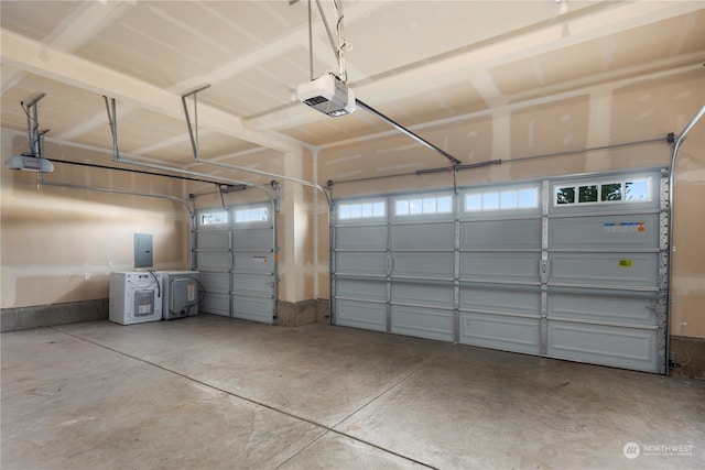 garage with a garage door opener, electric panel, and washer and dryer