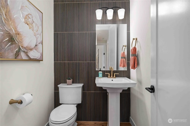 bathroom with tile walls and toilet