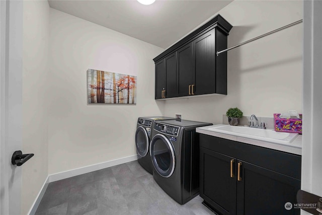 washroom with cabinets, washer and dryer, and sink