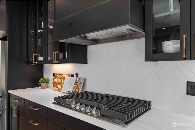 kitchen featuring backsplash, custom range hood, and gas cooktop