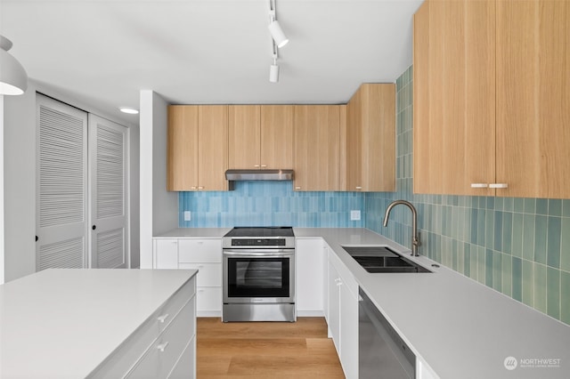 kitchen featuring sink, light hardwood / wood-style flooring, stainless steel appliances, light brown cabinetry, and decorative backsplash