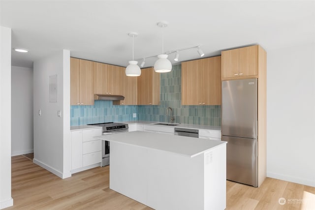 kitchen featuring appliances with stainless steel finishes, light hardwood / wood-style floors, backsplash, a center island, and decorative light fixtures