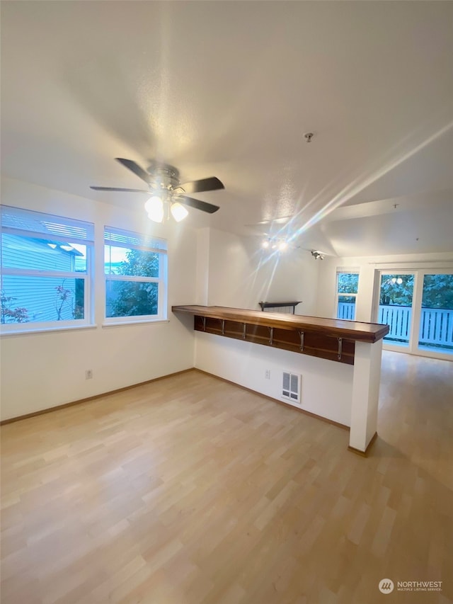 unfurnished living room with ceiling fan and hardwood / wood-style floors