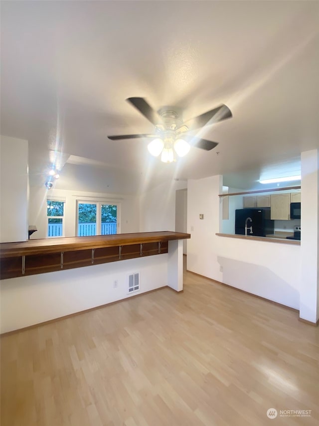 unfurnished living room featuring wood-type flooring and ceiling fan