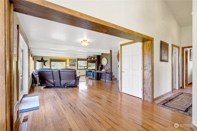 living room with light wood-type flooring and beamed ceiling