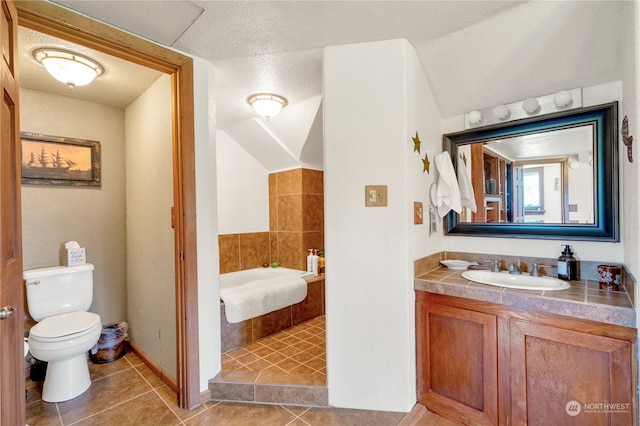 bathroom featuring tile patterned flooring, a textured ceiling, a bath, vanity, and toilet