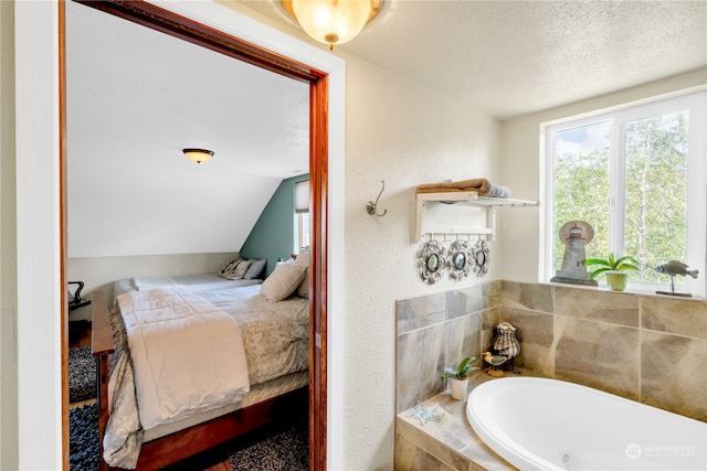 bathroom featuring tiled tub, a textured ceiling, and lofted ceiling