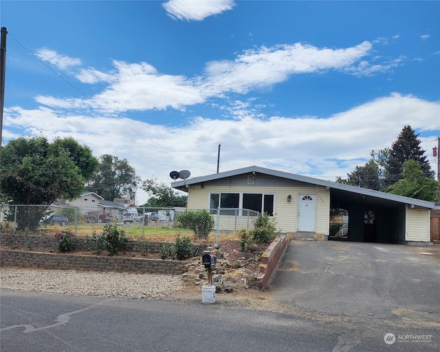 view of front of property with fence, a carport, and aphalt driveway